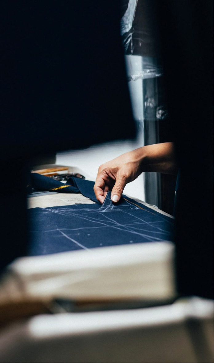 Hands guiding navy fabric through production